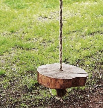 Une balançoire avec une corde et un morceau de bois
